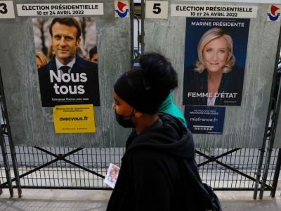 Люди проходят мимо официальных предвыборных плакатов кандидатов в президенты Франции Марин Ле Пен и Эммануэля Макрона. Фото: Gonzalo Fuentes / REUTERS