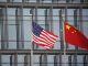 Флаги Китая и США развеваются у здания американской компании в Пекине. Фото: Tingshu Wang / Reuters